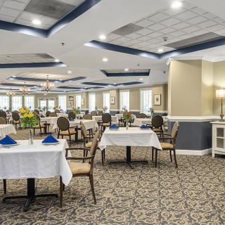 A spacious and elegantly decorated dining area with neatly arranged tables and chairs.