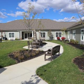 A landscaped courtyard with benches and pathways in front of a residential building.