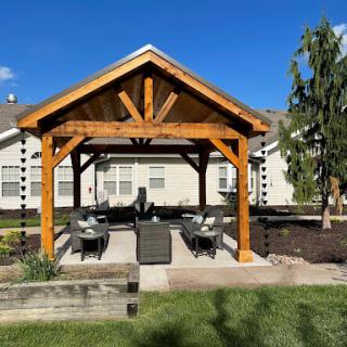 A beautifully designed wooden pergola providing a cozy outdoor seating area.
