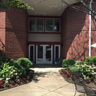 A building entrance with a brick exterior and well-maintained landscaping.