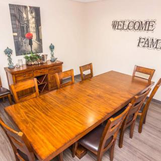 A warm and inviting dining room with a large wooden table and chairs, complemented by wall art and decor.