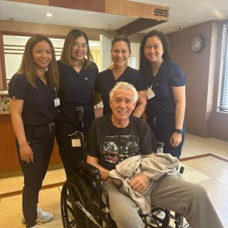 A joyful moment with healthcare professionals and a patient in a hospital setting.
