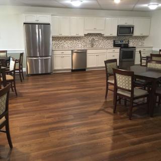 A spacious modern kitchen with a dining area, featuring hardwood floors and stainless steel appliances.
