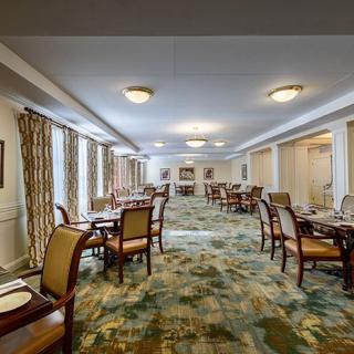 A well-lit dining room with arranged tables and chairs featuring elegant decor.