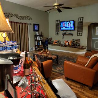 A cozy living room with a TV, leather chairs, and decorative elements.