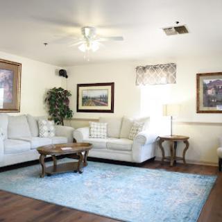 A cozy living room featuring a light-colored sofa, a wooden coffee table, and a decorative area rug.