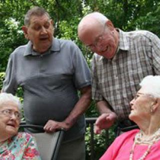 A group of seniors enjoying a conversation outdoors.
