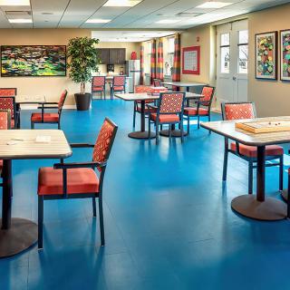 Bright and spacious cafeteria with colorful chairs and tables.