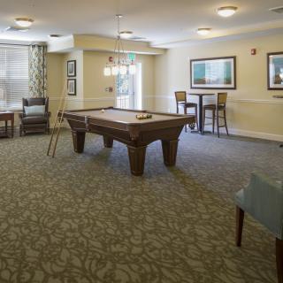 A cozy game room featuring a pool table and comfortable seating.