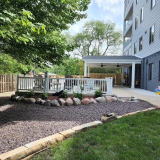 A serene backyard with a deck and patio area, surrounded by trees and landscaping.