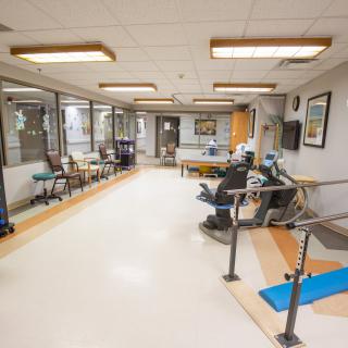 A hospital waiting area with chairs and medical equipment.
