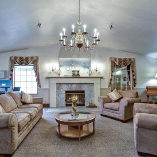 Elegant living room with a chandelier, two sofas, and a fireplace.