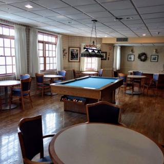 A spacious game room featuring a pool table and comfortable seating arrangements.