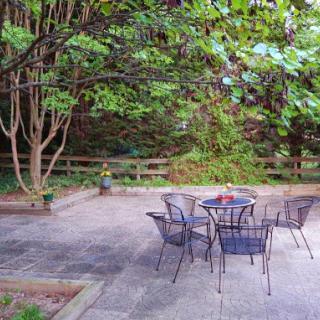 A peaceful outdoor patio surrounded by greenery, perfect for relaxation.