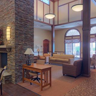 A spacious and cozy lobby with a fireplace, seating area, and large windows.