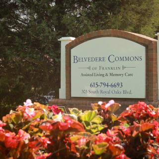 A sign for Bristoe Commons surrounded by blooming flowers.