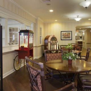 A cozy dining area featuring a popcorn machine and jukebox, with a table and chairs arranged for comfort.