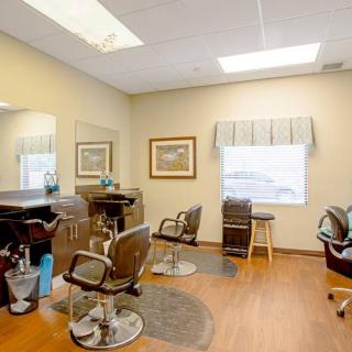 A well-lit salon interior with several styling chairs and mirrors.
