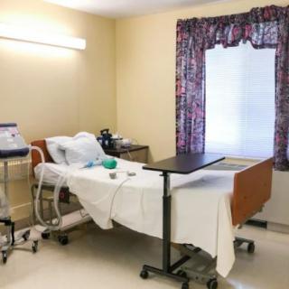 A tidy hospital room with a medical bed and attached equipment.