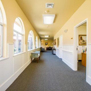A bright hallway with arched windows and yellow walls.
