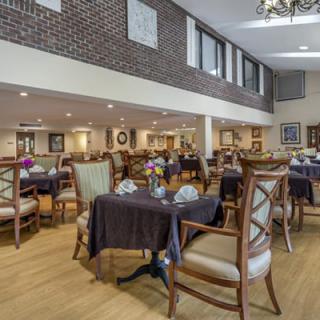 A spacious dining area with elegant tables and chairs, featuring modern decor and brick walls.