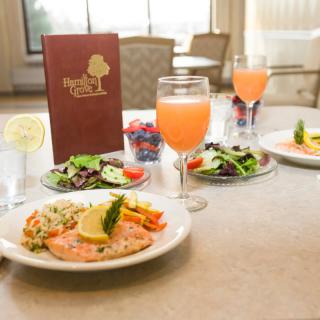 A beautifully presented meal featuring salmon, salad, and a refreshing beverage at a restaurant.