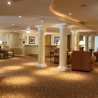 A spacious lobby with a seating area, reception desk, and elegant lighting.