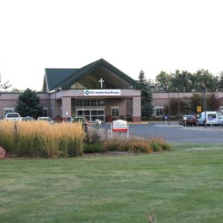 A view of a healthcare facility surrounded by landscaped grounds.