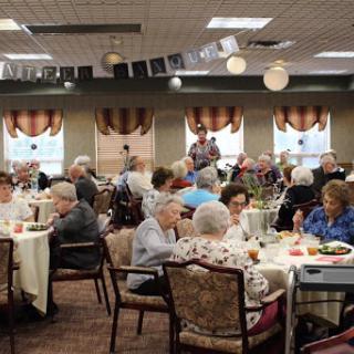 An engaging social gathering for the elderly, featuring dining and live music entertainment.