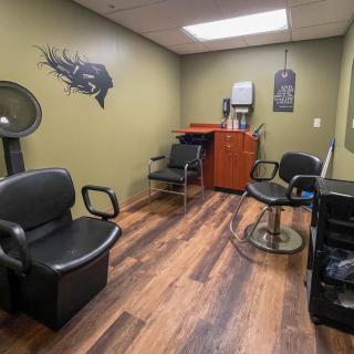 A cozy hair salon interior with styling chairs and equipment.