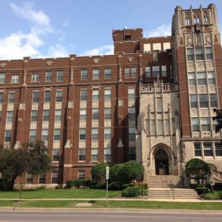 A historic brick school building with a prominent entrance.