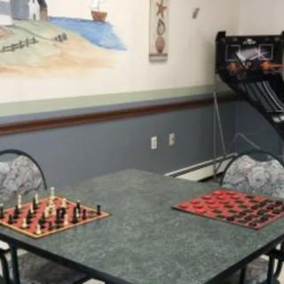 A game room with chess and checkers set up on a table.