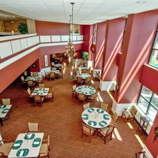 Spacious dining area with neatly arranged tables and natural light streaming through large windows.