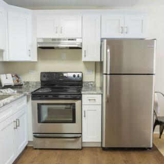 A modern kitchen with stainless steel appliances and white cabinets.