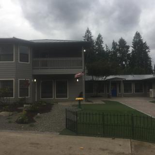 A two-story house with an overcast sky and a neatly kept garden.