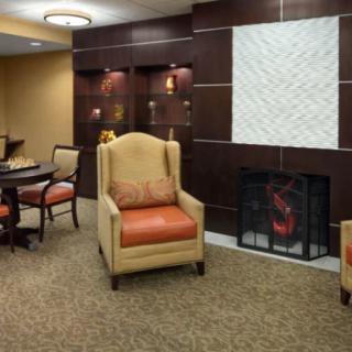 A cozy living room with an armchair and a fireplace.