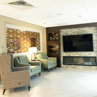 A modern lounge area with stylish chairs, a large television, and decorative elements.
