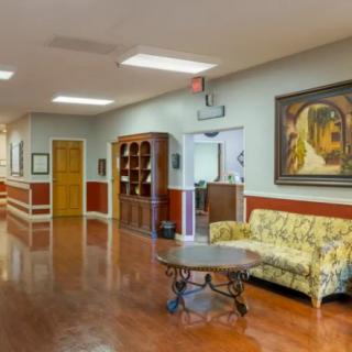 A well-decorated hallway with a sofa, table, and artwork on the walls.