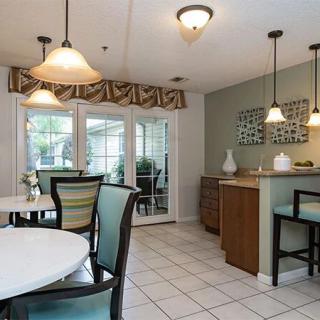 Modern kitchen and dining area with pendant lighting and wooden furniture.