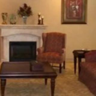 A cozy living room with a fireplace, armchair, and elegant decor.