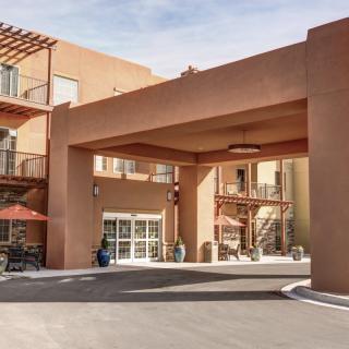 A hotel entrance with southwestern architectural design and a driveway.