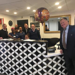 Staff members gather at the reception area to celebrate a special occasion.