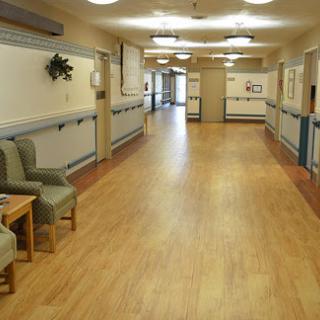 A spacious and well-lit healthcare hallway with seating areas.