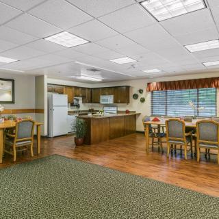 A spacious kitchen and dining area with wooden flooring, equipped with modern appliances and comfortable seating.