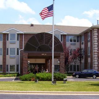 A welcoming hotel entrance with an American flag waving in front.
