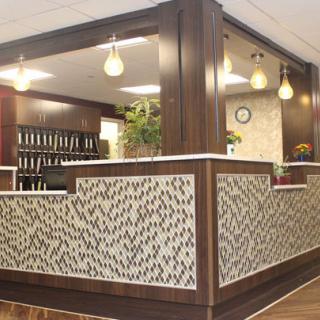 A modern office reception area with wood paneling and decorative lighting.