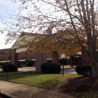 A view of a building surrounded by trees and greenery during autumn.