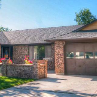 A charming brick house with a driveway and attached garage.