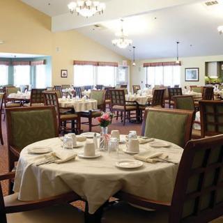 A well-set dining area with multiple tables and chairs, ready for guests.