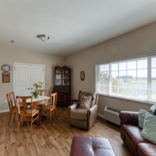 A cozy living room with a dining area, featuring wooden flooring and comfortable seating.